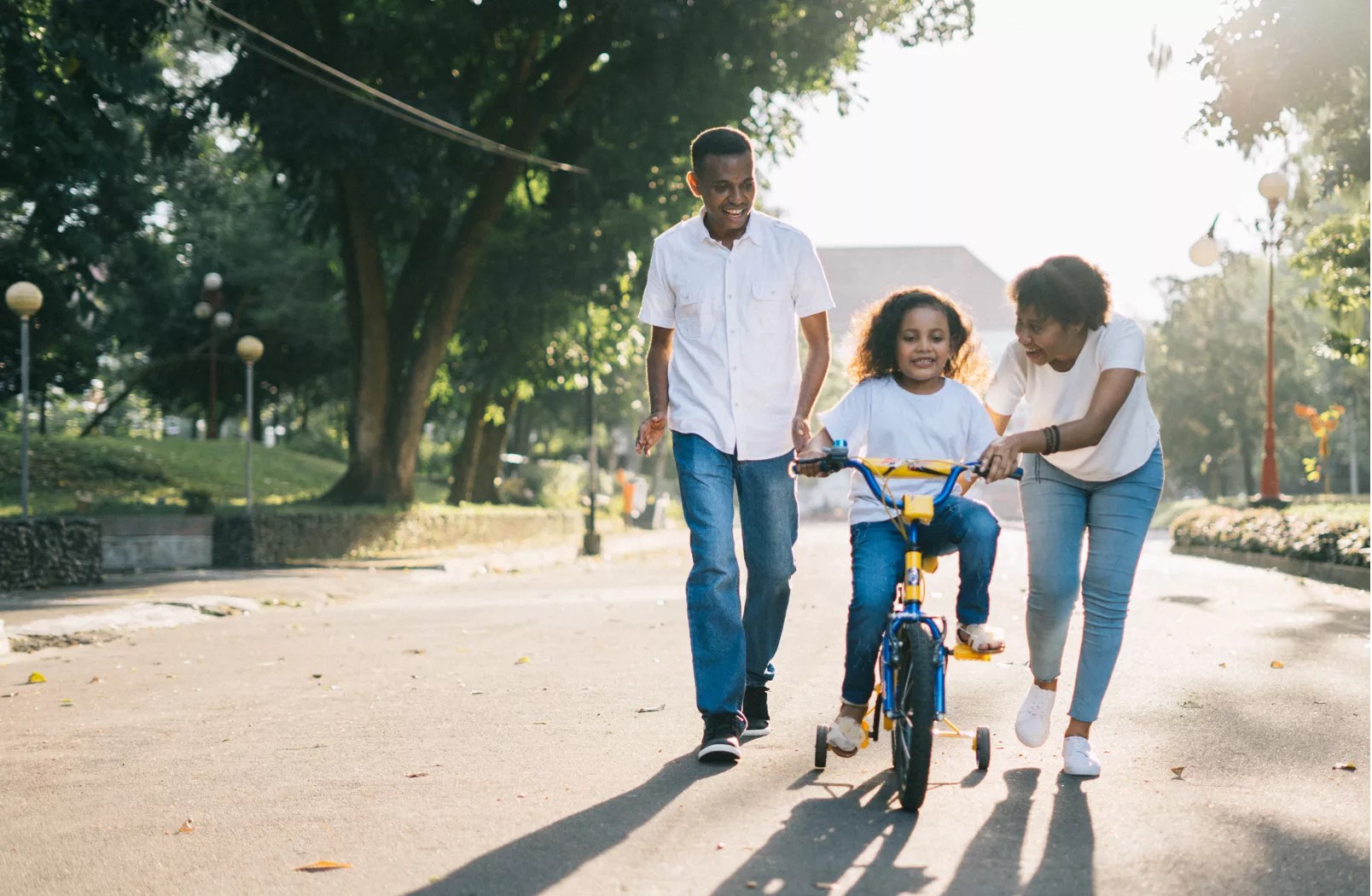 Black family teaching their daughter to ride a bike